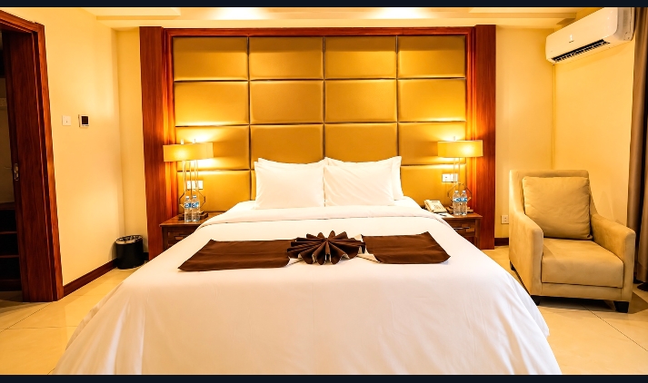Deluxe Suite with statement gold headboard — Summerset Continental Hotel Abuja