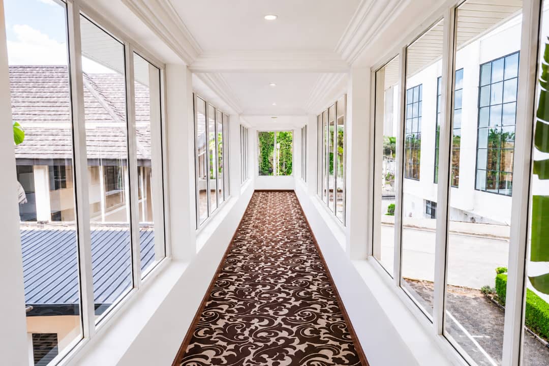 Signature glass-walled corridor walkway — Summerset Continental Hotel Abuja